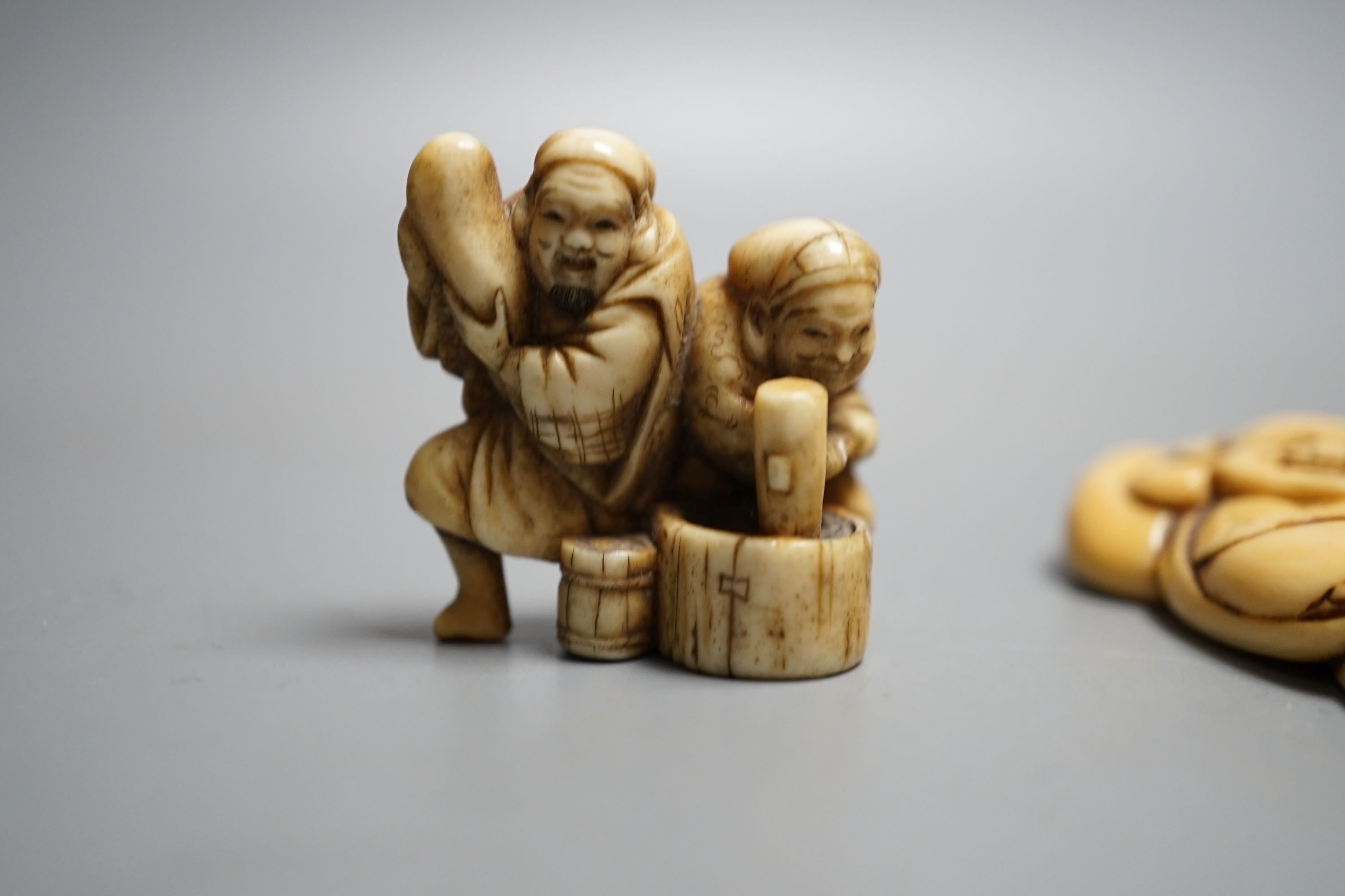 A Japanese Edo period ivory netsuke of Hotei and a Meiji period ivory netsuke of Daikoku and Ebisu, largest 6.5 cms high.
